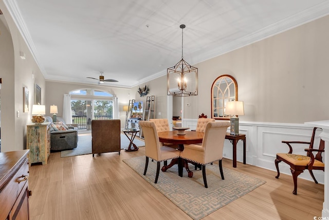 dining area featuring ceiling fan with notable chandelier, light wood-type flooring, and crown molding