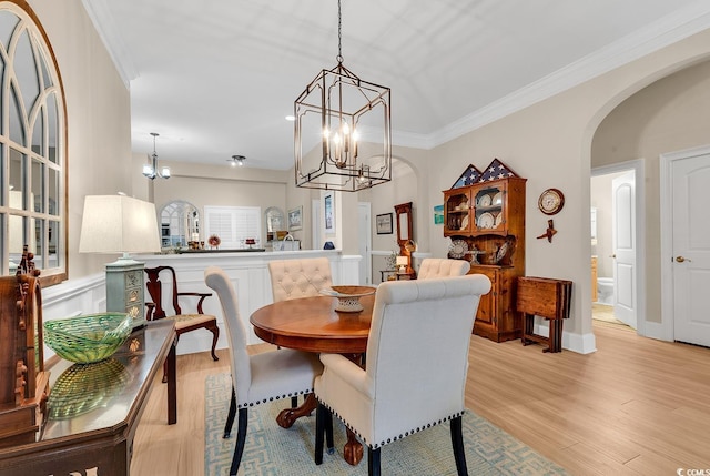 dining area with a chandelier, light hardwood / wood-style floors, and ornamental molding