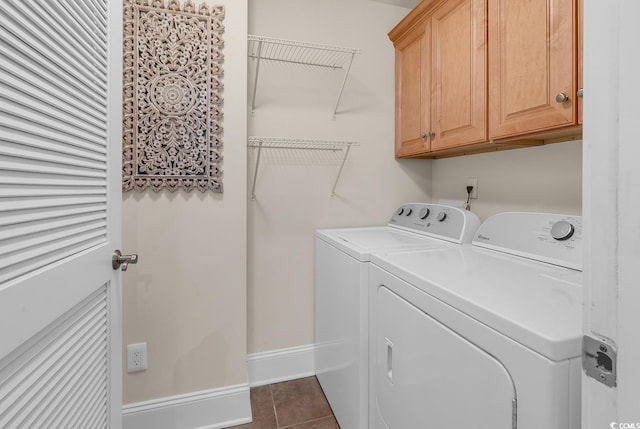 washroom featuring washer and clothes dryer, cabinets, and dark tile patterned flooring