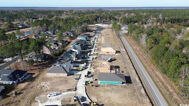 aerial view of property's location featuring a forest and nearby suburban area
