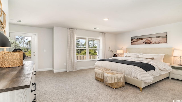 carpeted bedroom featuring multiple windows and baseboards