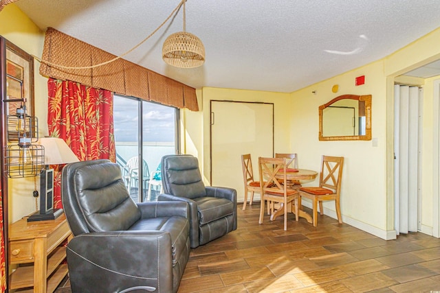 living room with a water view, a textured ceiling, and dark hardwood / wood-style flooring