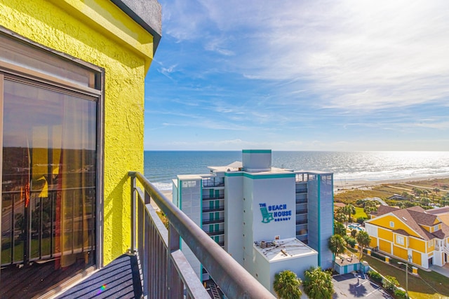 balcony with a water view and a view of the beach