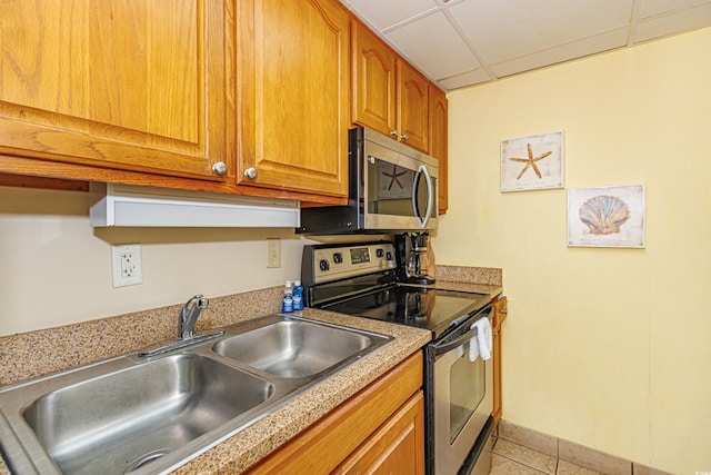 kitchen featuring sink, light tile patterned floors, a paneled ceiling, and stainless steel appliances