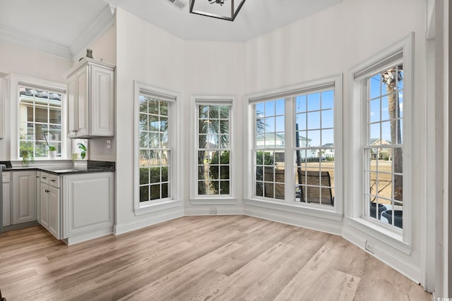 unfurnished sunroom featuring plenty of natural light and a notable chandelier