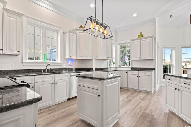 kitchen with stainless steel dishwasher, a kitchen island, white cabinetry, and sink