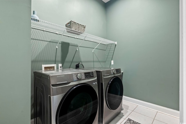 laundry area featuring washer and dryer and light tile patterned flooring