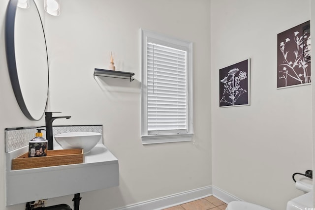 bathroom with toilet, tile patterned floors, and sink