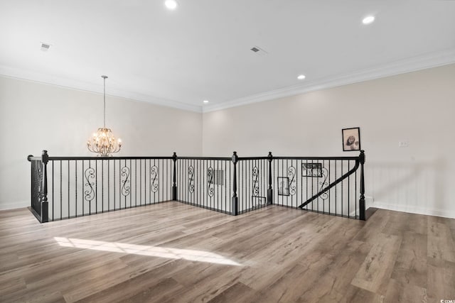 hall with crown molding, hardwood / wood-style floors, and a chandelier