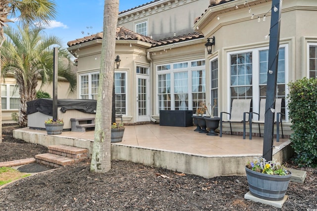 back of property with a patio area and a hot tub