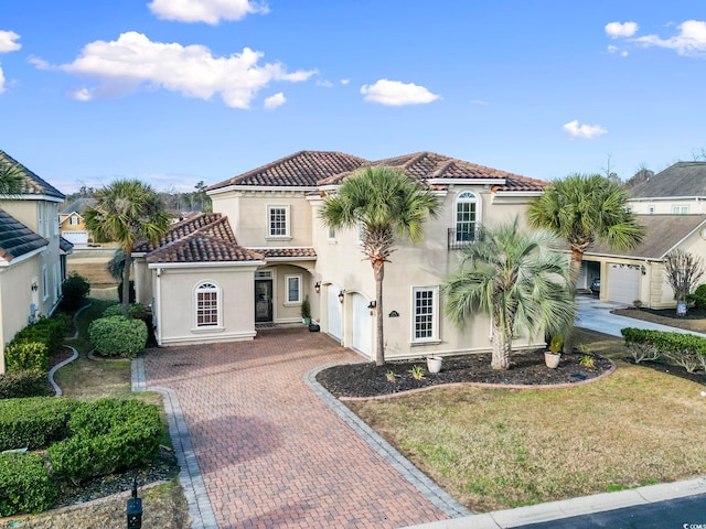 mediterranean / spanish-style house with a garage and a front lawn