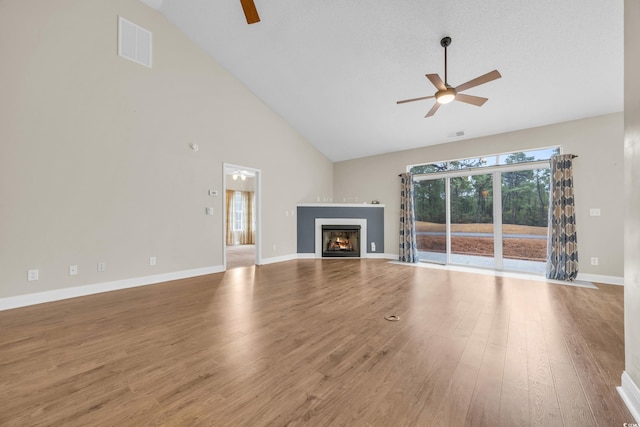 unfurnished living room featuring hardwood / wood-style floors, high vaulted ceiling, and ceiling fan