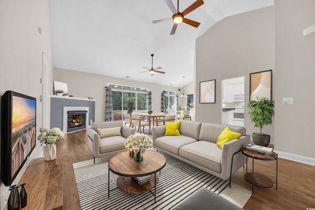 living room with dark hardwood / wood-style floors, ceiling fan, and lofted ceiling