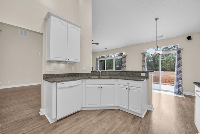 kitchen featuring dishwasher, white cabinets, sink, light wood-type flooring, and kitchen peninsula