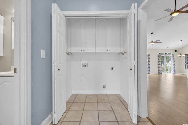 washroom featuring electric dryer hookup, cabinets, hookup for a washing machine, light tile patterned floors, and a textured ceiling