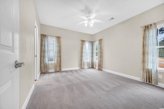 carpeted spare room featuring ceiling fan