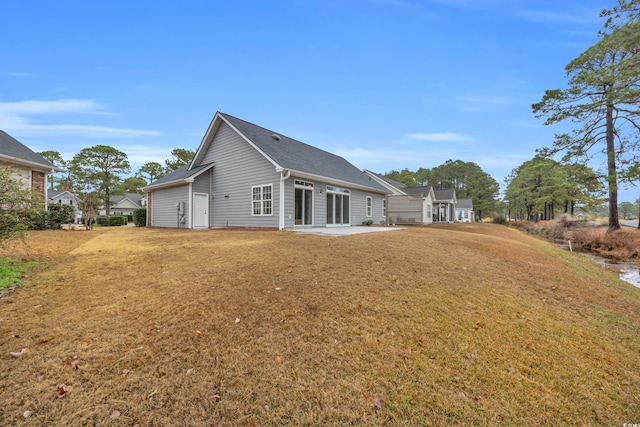 back of house with a patio and a lawn