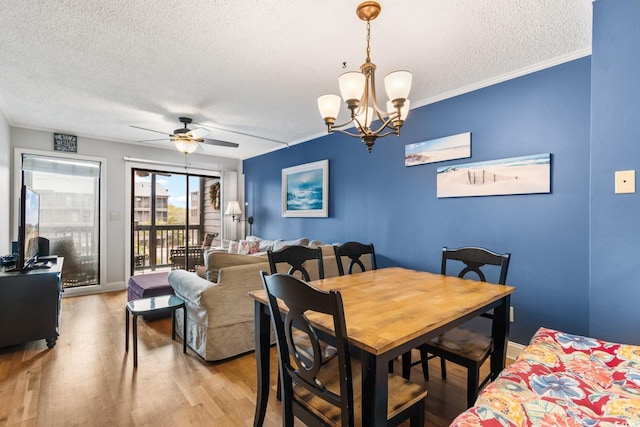 dining area with crown molding, light wood-style flooring, a textured ceiling, baseboards, and ceiling fan with notable chandelier