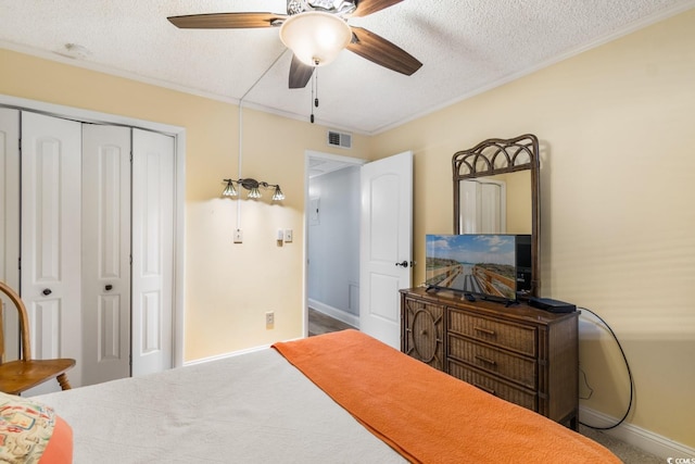 bedroom featuring a closet, visible vents, a ceiling fan, ornamental molding, and a textured ceiling