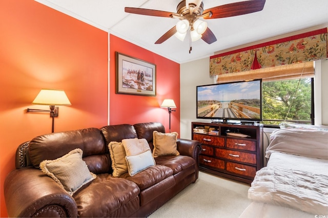 living room with ceiling fan, crown molding, and light colored carpet