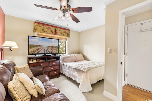 bedroom featuring baseboards, ceiling fan, light wood finished floors, and crown molding