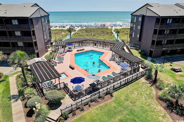 community pool with a water view and a beach view