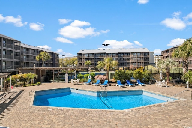 community pool featuring a patio and fence