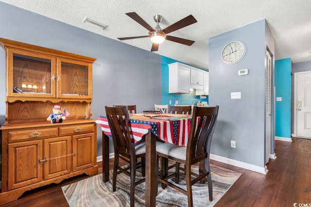 dining space with a textured ceiling, a ceiling fan, baseboards, vaulted ceiling, and dark wood-style floors