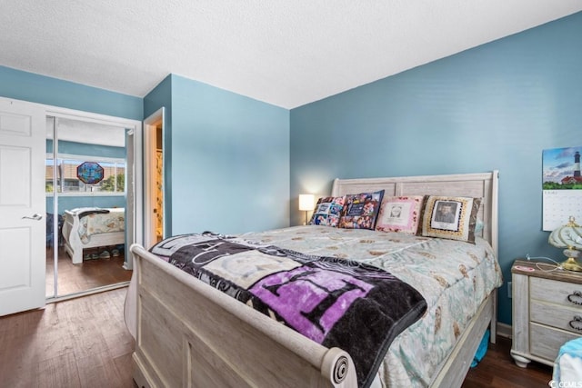 bedroom featuring a textured ceiling and dark wood-style flooring