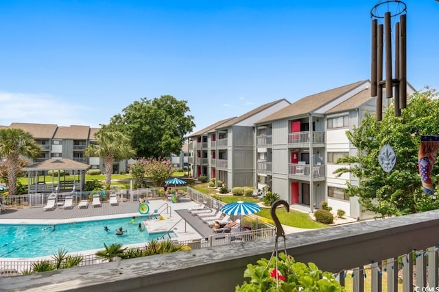 community pool with a patio area and fence