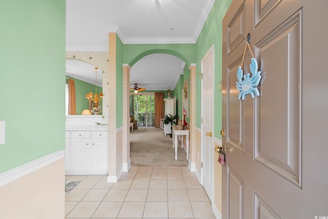 carpeted foyer featuring crown molding, ceiling fan, and a textured ceiling