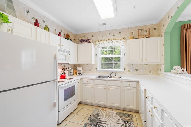 kitchen featuring white cabinetry, sink, light tile patterned floors, crown molding, and white appliances