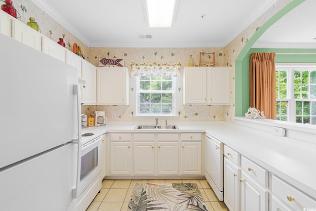 kitchen featuring sink, light tile patterned floors, ornamental molding, white appliances, and white cabinets