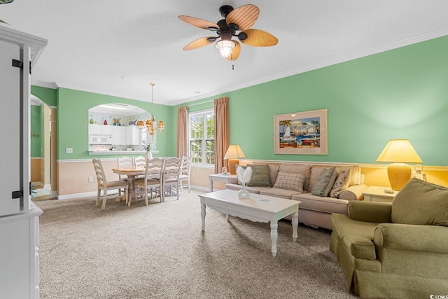 living room featuring crown molding, carpet flooring, and ceiling fan