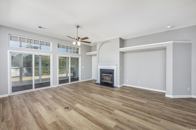 unfurnished living room with ceiling fan and light hardwood / wood-style flooring