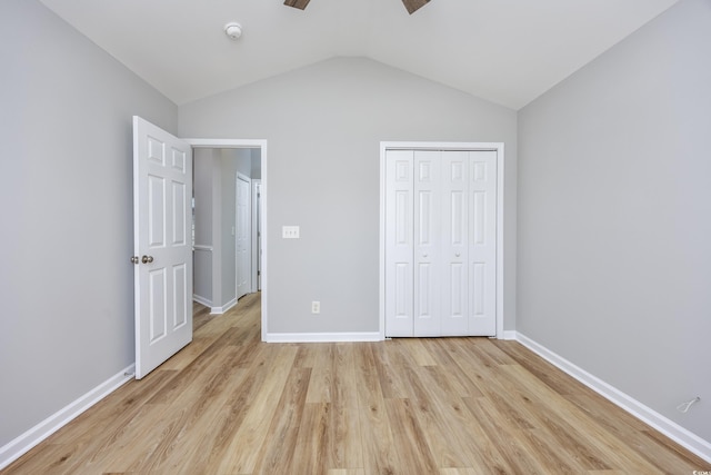 unfurnished bedroom featuring ceiling fan, a closet, vaulted ceiling, and light hardwood / wood-style flooring