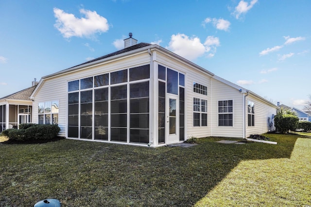 view of side of property featuring a lawn and a sunroom