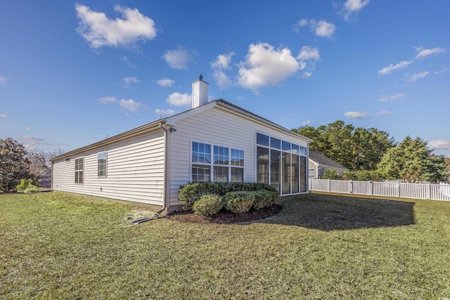 view of side of property with a lawn and a sunroom