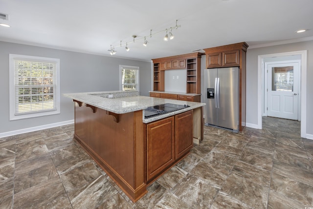 kitchen with light stone countertops, a center island, a kitchen breakfast bar, stainless steel fridge with ice dispenser, and ornamental molding