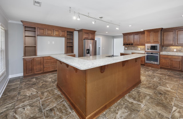 kitchen featuring tasteful backsplash, crown molding, a spacious island, a kitchen bar, and appliances with stainless steel finishes