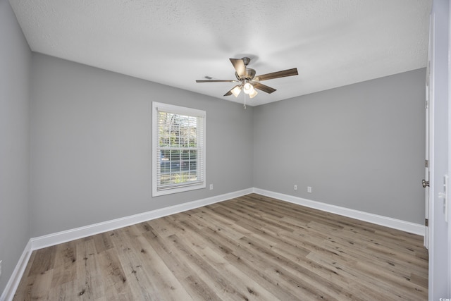 empty room with light hardwood / wood-style floors and a textured ceiling