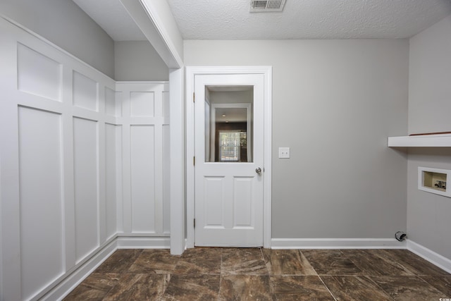 laundry room featuring washer hookup and a textured ceiling