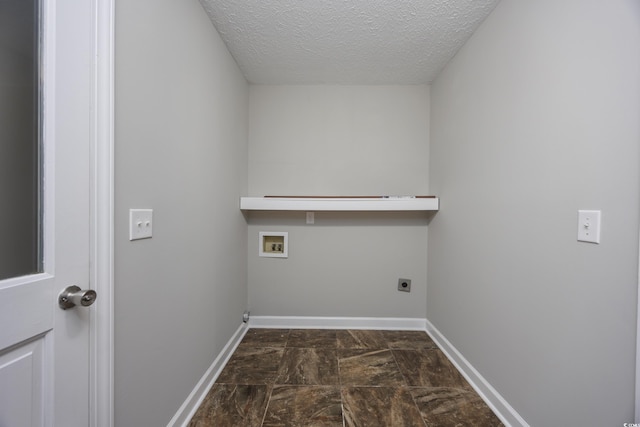 washroom featuring hookup for an electric dryer, a textured ceiling, and hookup for a washing machine