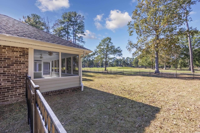 view of yard featuring a rural view, ceiling fan, and a sunroom