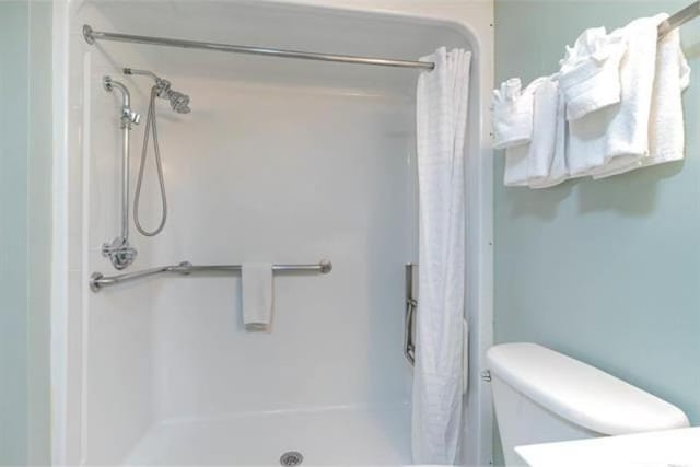 bathroom featuring a shower with shower curtain and toilet