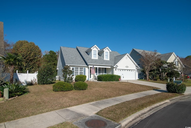 cape cod home featuring a front yard and a garage