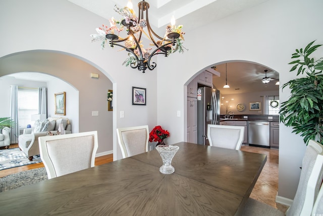 dining area with ceiling fan with notable chandelier and light tile patterned flooring