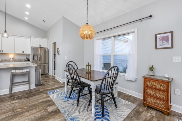 dining room featuring dark hardwood / wood-style flooring, lofted ceiling, and a chandelier