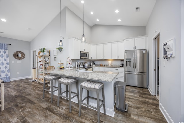 kitchen featuring hanging light fixtures, stainless steel appliances, high vaulted ceiling, kitchen peninsula, and white cabinets