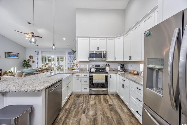 kitchen with pendant lighting, kitchen peninsula, appliances with stainless steel finishes, dark hardwood / wood-style flooring, and white cabinetry